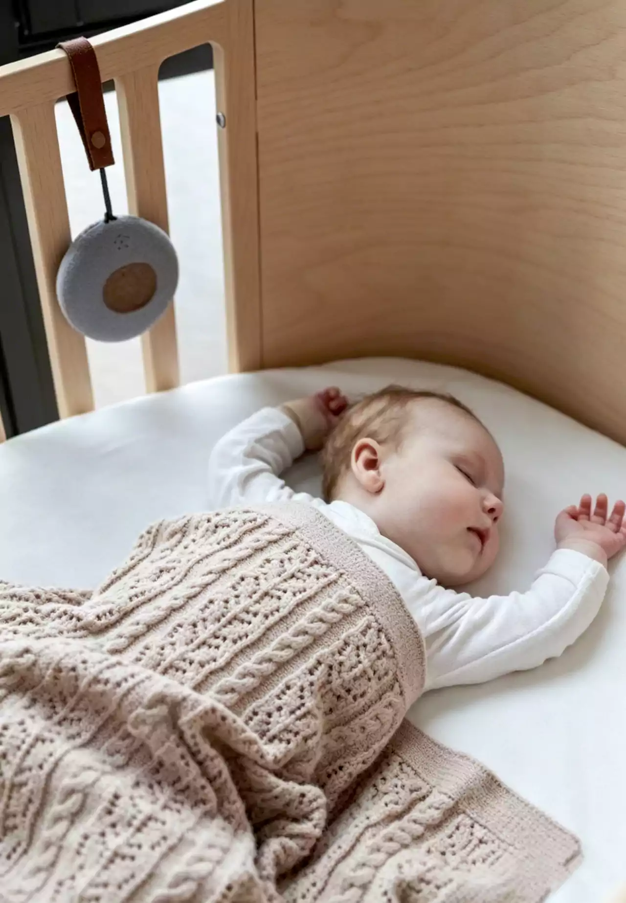Infant wearing B601 wristband in crib, BG601 gateway mounted on wall nearby